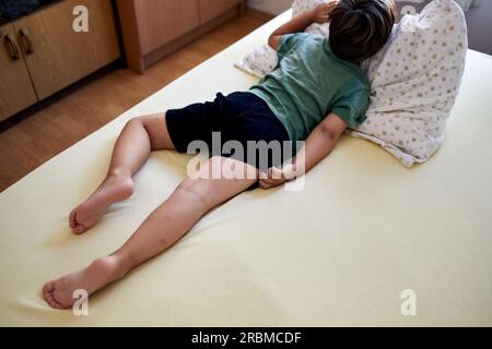 Beaucoup de piqûres de moustiques font mal et cicatrice sur les jambes de l'enfant, un garçon grattant à la lésion. Banque D'Images