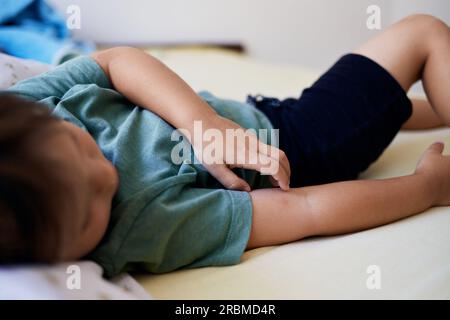 Moustique mordant la plaie et la cicatrice sur la main de l'enfant, un garçon grattant à la lésion. Banque D'Images