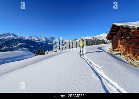 Femme sur un tour de ski ascendant à False Riedel, False Riedel, Alpes de Kitzbühel, Tyrol, Autriche Banque D'Images