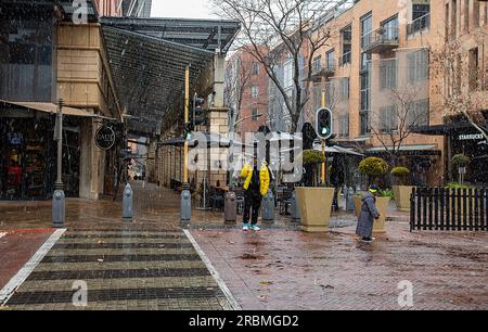 (230710) -- JOHANNESBURG, 10 juillet 2023 (Xinhua) -- les gens marchent alors que la neige tombe à Melrose Arch à Johannesburg, Afrique du Sud, le 10 juillet 2023. (Xinhua/Zhang Yudong) Banque D'Images