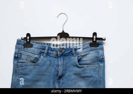 Short pour hommes en denim sur un cintre sur un fond blanc, vêtements à la mode Banque D'Images