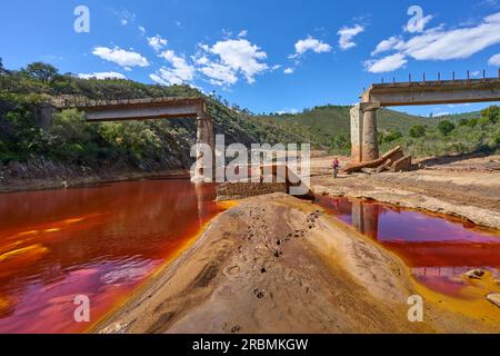 Belle femme avec vélo de montagne électrique sur un tour à vélo le long de la rivière Rio Tinto avec son eau rouge naturelle en Andalousie, Espagne Banque D'Images