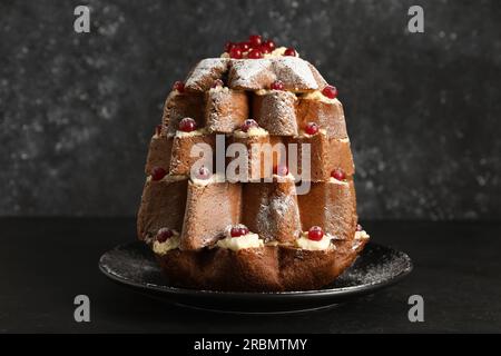 Délicieux gâteau d'arbre de Noël Pandoro avec sucre en poudre et baies sur la table noire Banque D'Images