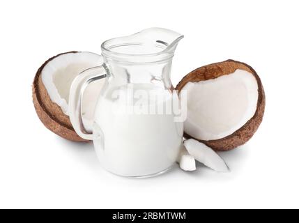 Pichet en verre de délicieux lait végétalien et noix de coco sur fond blanc Banque D'Images