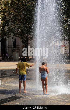Rafraîchissement dans la fontaine Zeus, sur la place du nombre d'Or, quartier Antigone. Montpellier, Occitanie, France Banque D'Images