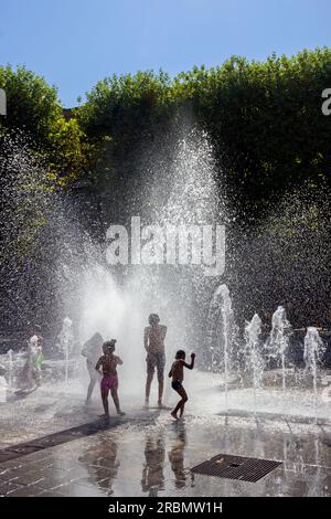 Rafraîchissement dans la fontaine Zeus, sur la place du nombre d'Or, quartier Antigone. Montpellier, Occitanie, France Banque D'Images