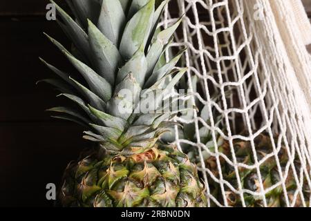 Ananas mûrs entiers et sac net, gros plan Banque D'Images