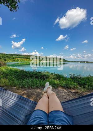 femme pov couchée sur hamac regardant le lac Banque D'Images