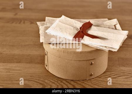 Vieilles lettres liées avec ruban sur la boîte sur la table en bois, les souvenirs passés Banque D'Images