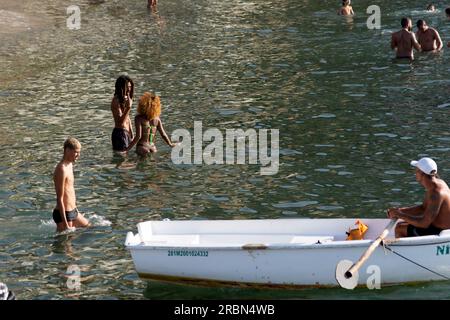 Salvador, Bahia, Brésil - 14 janvier 2022: Les gens sont vus se baigner dans la mer et bronzer sur les sables de la plage dans la communauté de Gamboa à Sal Banque D'Images