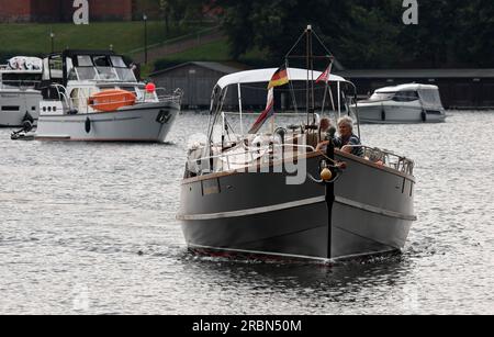 Malchow, Allemagne. 10 juillet 2023. Les navires à passagers et les marcheurs nautiques mettent le cap sur le pont tournant ouvert. Le soleil s'est fait rare, les nuages et la pluie déterminent le temps qu'il fait dans le district des lacs de Mecklenburg. Crédit : Bernd Wüstneck/dpa/Alamy Live News Banque D'Images