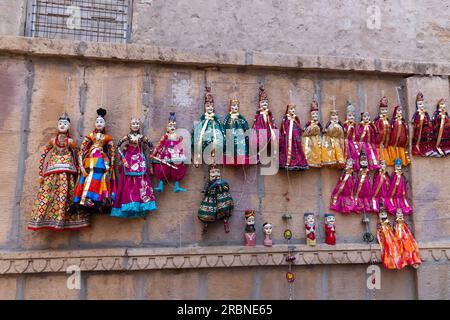 Jaisalmer, Rajasthan, Inde - 16 octobre 2019 : poupées traditionnelles Rajasthan Raja Rani suspendues au mur à vendre près de Patwon Ki Haveli. Banque D'Images