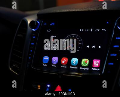 Gros plan de l'écran tactile de tableau de bord intérieur de voiture moderne, panneau de moniteur tactile automatique Android à l'intérieur du véhicule la nuit, détail photographié de près, éclairé. Banque D'Images
