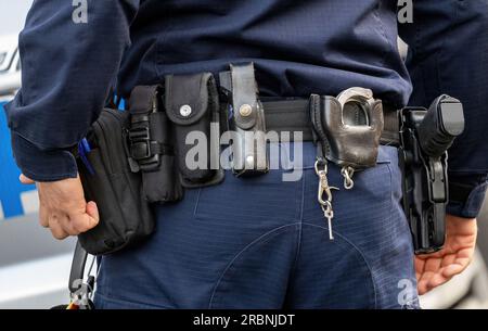 Policier, ceinture utilitaire d'équipement de police avec un pistolet, spray de poivre et divers accessoires, plan de détail, gros plan vu de derrière les outils d'agent de police Banque D'Images