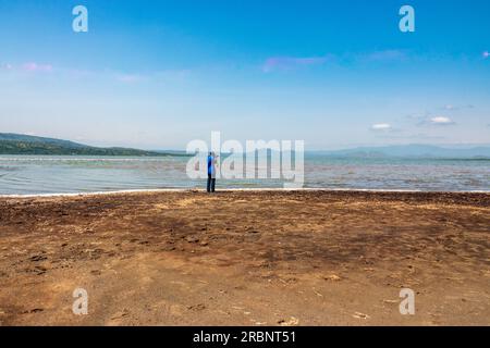 Vue arrière d'un photographe prenant des photos au bord du lac Elementaita à Naivasha, Kenya Banque D'Images