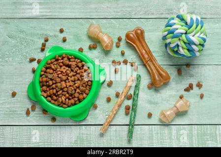Composition avec de la nourriture pour chien différente et boule de jouet sur fond en bois de couleur Banque D'Images