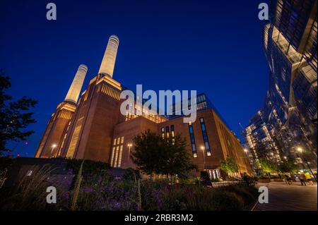 Battersea, Londres, Royaume-Uni : Battersea Power Station est maintenant réaménagé pour devenir une destination de shopping et de loisirs. Vue nocturne avec Circus Road West et fleurs Banque D'Images