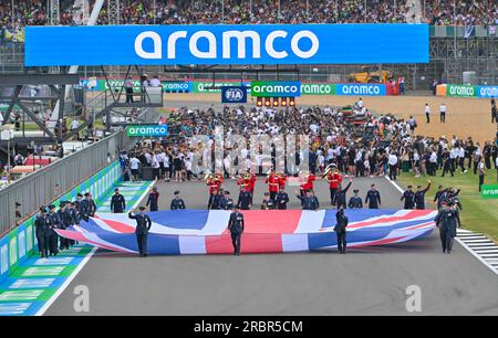 Silverstone, Towcester, Northamptonshire, Royaume-Uni le 09 2023 juillet. La marche de la grille et l'hymne national sont terminés alors que le drapeau britannique de l'Union défile sur Hamilton Straight avant le départ de la course sur la ligne de départ lors de la course de Formule 1 au Grand Prix britannique Aramco de Formule 1 à Silverstone, Towcester, Northamptonshire, Royaume-Uni le 09 2023 juillet. Francis Knight/Alamy Live News Banque D'Images