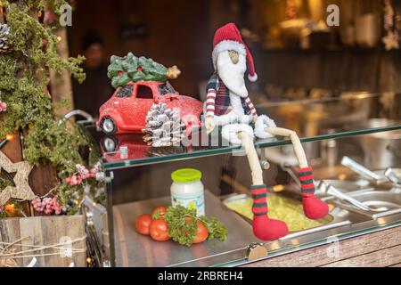 Décoration d'un stand de nourriture à un marché de noël avec poupée de chiffon et voiture de jouet transporter un arbre de noël. Banque D'Images