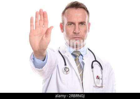 Médecin ou infirmier portant une blouse de laboratoire tenant sa main dans un geste d'arrêt avec une expression implacable sévère comme il empêche l'accès ou dit Banque D'Images