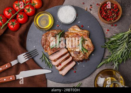 Morceaux de délicieuse viande frite au romarin servis sur une table brune, mise à plat Banque D'Images