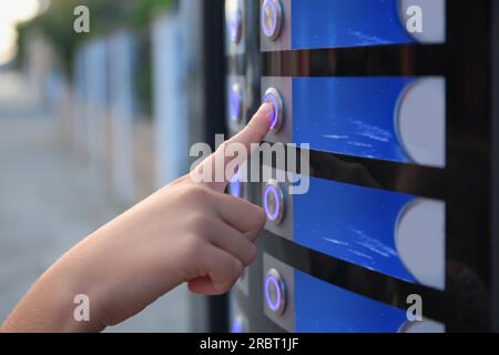 Utilisation d'un distributeur automatique de café. Femme appuyant sur le bouton pour choisir la boisson, closeup Banque D'Images