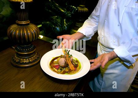 Servant un plat de côtelettes de porc et de légumes, Hôtel Fairmont Reine Elizabeth, Montréal, Québec, Canada Banque D'Images