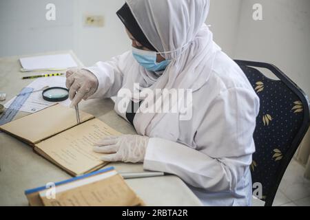 Gaza, Palestine. 10 juillet 2023. Une palestinienne spécialisée dans la conservation, la restauration et la numérisation de manuscrits et de livres rares travaille dans un laboratoire de la Fondation « Eyes on Heritage » pour les études, la recherche et l'édition dans la ville de Gaza. Les palestiniennes travaillent à l'archivage et à la restauration de manuscrits et de livres historiques rares anciens dans un laboratoire financé par la British Library de Londres et le Hill Museum. Crédit : SOPA Images Limited/Alamy Live News Banque D'Images