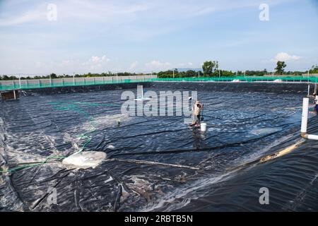 Plusieurs éleveurs d'étangs nettoient les étangs en plastique LDPE avant de commencer à mettre de l'eau dans les étangs d'élevage de poissons vanamei et de crevettes Banque D'Images