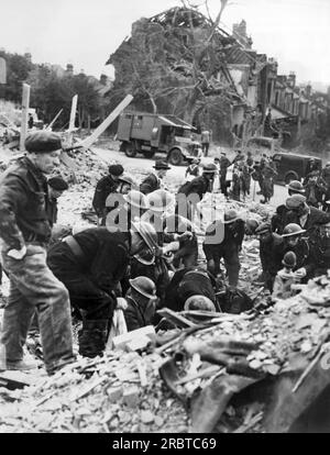 Londres, Angleterre : c. 1943 secouristes de la Défense civile cherchant les ruines pour les victimes et les survivants après qu'une bombe volante allemande V-1 ait frappé le quartier de Balham à Londres. Banque D'Images