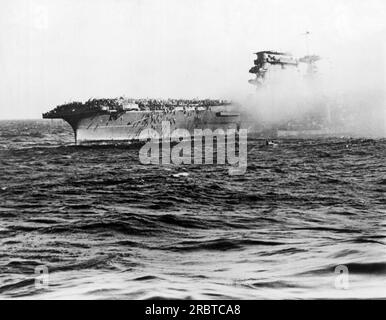 Mer de corail, Papouasie-Nouvelle-Guinée : mai 1942 États-Unis Les hommes de la Marine accumulent des cordes sur le côté du porte-avions USS Lexington après que le capitaine ait donné l'ordre d'abandonner le navire après qu'il ait été touché par des avions japonais. Banque D'Images
