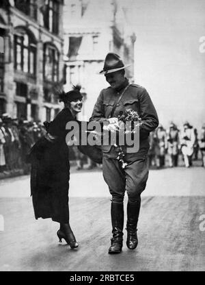 New York, New York : 7 août 1919 Une jeune femme donnant un bouquet de fleurs à un soldat de retour de la première Guerre mondiale dans le défilé Welcome Home Banque D'Images