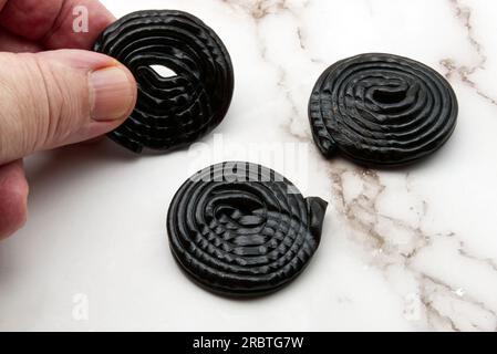 Délicieuses bonbons à la réglisse noire sur fond de marbre blanc Banque D'Images