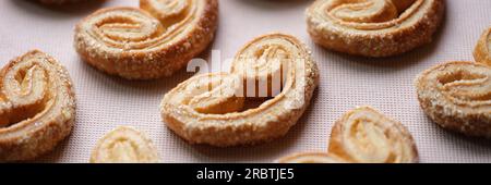 De nombreux biscuits en forme de cœur sont disposés sur la nappe. Banque D'Images