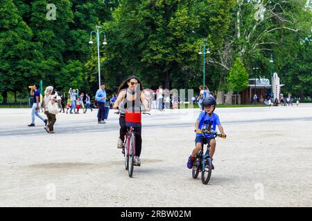 MILAN, ITALIE - 19 MAI 2018 : il s'agit d'une femme non identifiée avec un enfant à vélo dans le parc Sempione par une journée ensoleillée de printemps. Banque D'Images