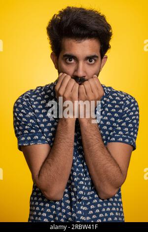 Homme indien déprimé stressé terrifié par les problèmes de danger, souffrant de phobie, trouble anxieux, exprime la peur, saluant non, insécurité, stress, panique. Mec hindou isolé sur fond de studio jaune Banque D'Images