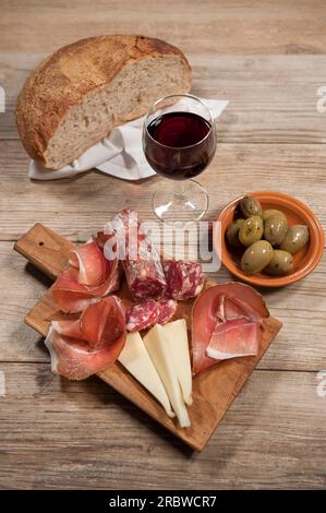 Jambon cru sarde, saucisse de porc crue sarde, assiette de fromage pecorino sarde, olives, pain de grains entiers, vin rouge, Sardaigne, Italie, Europe Banque D'Images