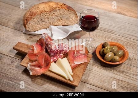 Jambon cru sarde, saucisse de porc crue sarde, assiette de fromage pecorino sarde, olives, pain de grains entiers, vin rouge, Sardaigne, Italie, Europe Banque D'Images