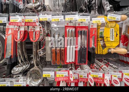 Italie - 10 juillet 2023 : couteaux de table, louches et outils de cuisine emballés sur étagère dans un supermarché italien Banque D'Images