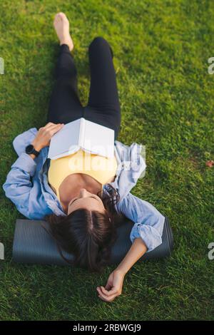 Femme de récolte couchée sur l'herbe Banque D'Images