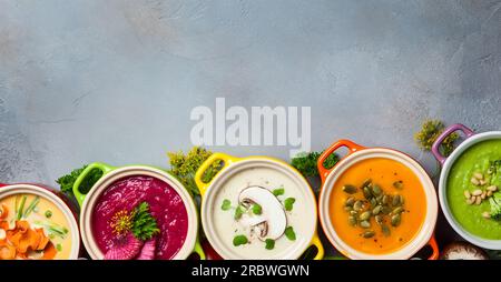 Variété de soupes à la crème de légumes colorés et ingrédients pour la soupe. Vue de dessus. Concept d'alimentation saine ou de nourriture végétarienne. Banque D'Images
