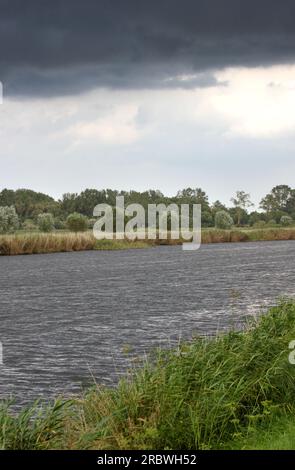 La rivière Ryck sous la pluie et la tempête à Mecklenburg-Vorpommern, Allemagne. L'image a été créée à l'aide d'une technique d'imagerie HDR. Banque D'Images