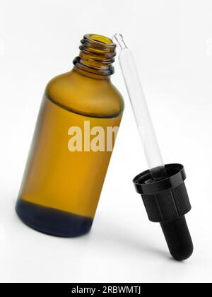 Flacon en verre brun avec pipette sur fond blanc Banque D'Images