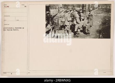 Soldat interrogeant un prisonnier dans le secteur italien pendant la première Guerre mondiale. La photographie, numérotée 111-SC-13281, capture le moment où le soldat gère l'interrogatoire. La photo a été prise par le photographe Reco selon la description fournie avec l'image. Banque D'Images