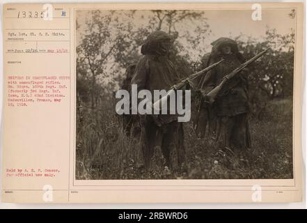 Sgt. 1e cl. C.H. White photographia un groupe de tireurs d'élite en costumes camouflés avec des fusils camouflés. La photo a été prise le 18 mai 1918 à BN. Hdqrs. 168th Regt. INF. (Anciennement 3rd Regt. INF. Iowa, N.G.) 42e division à Badonviller, France. Cette photo a été détenue par l'A.E.F. Censurer pour usage officiel seulement. Banque D'Images
