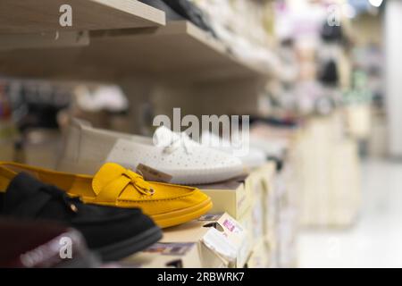 Gros plan de ballerines jaunes en daim pour femmes sur une étagère dans un magasin de chaussures. Collection de chaussures pour femmes Banque D'Images