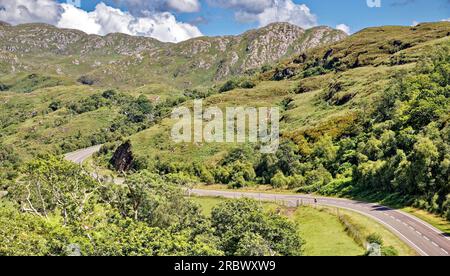 Route vers les îles l'A830 fort William à Mallaig côte ouest de l'Écosse en été avec un cycliste solitaire Banque D'Images