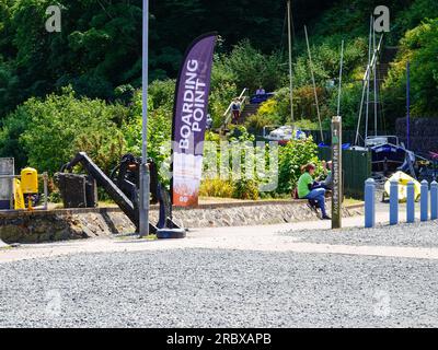 Personnes au point d'embarquement panneau et marqueur pour le départ du sentier côtier d'Aros Park, Tobermory, île de Mull, Écosse, Royaume-Uni. Banque D'Images