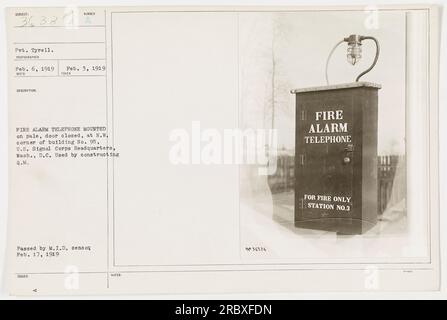 Le soldat Tyrell se tient à côté d'un téléphone d'alarme incendie monté sur une pâle. La photographie a été prise le 6 février 1919 aux États-Unis Quartier général du corps des signaux à Washington D.C. Le téléphone de l'alarme incendie est étiqueté Station No. 3 et est utilisé pour signaler les incendies seulement. La photo a été approuvée par le censeur interne militaire le 17 février 1919. Banque D'Images