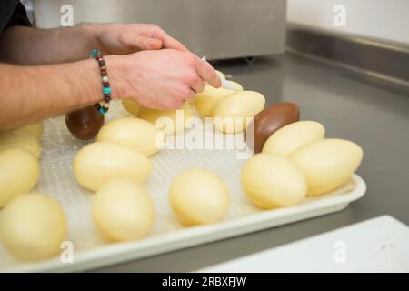 confiseur décorant des oeufs en chocolat Banque D'Images